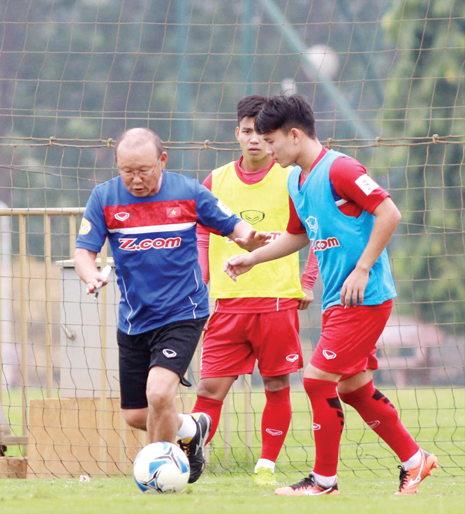 HLV Park Hang Seo làm động tác thị phạm cho các cầu thủ trong buổi tập đầu tiên của ĐTVN dưới thời HLV người Hàn Quốc. Ảnh: VSI.