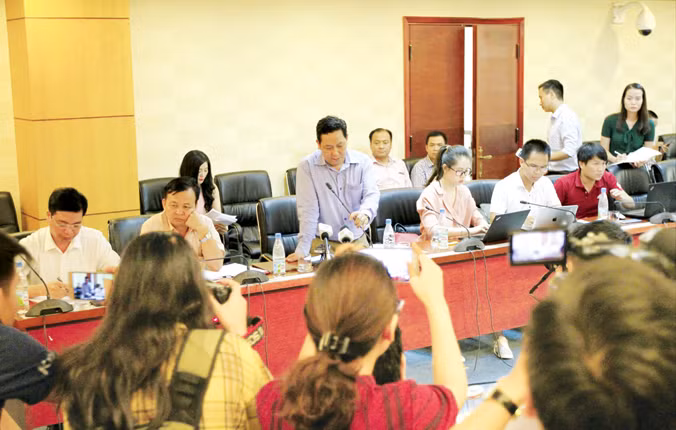 Ông Nguyễn Xuân Quang (đứng giữa) trả lời báo chí xung quanh vụ việc mất tiền. Ảnh: Trường Phong.