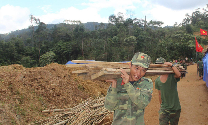 Các chiến sỹ giúp người dân dựng nhà ở nơi ở mới.