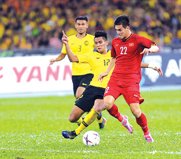 Hậu vệ Malaysia cản phá pha dứt điểm của Tiến Linh trong trận chung kết lượt đi. Ảnh: VSI