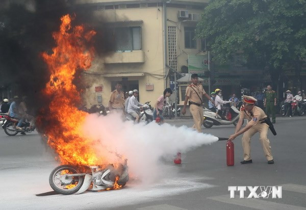 Cảnh sát giao thông dập lửa bằng bình cứu hỏa (Ảnh: Vũ Đức-TTXVN)