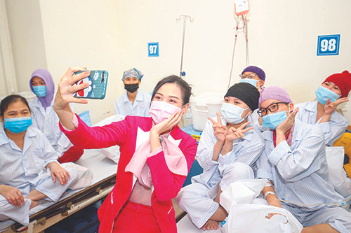 Hoa hậu Đỗ Thị Hà chụp ảnh cùng các bệnh nhân khi thăm tặng quà tại Viện Huyết học và Truyền máu T.Ư Ảnh: Như Ý