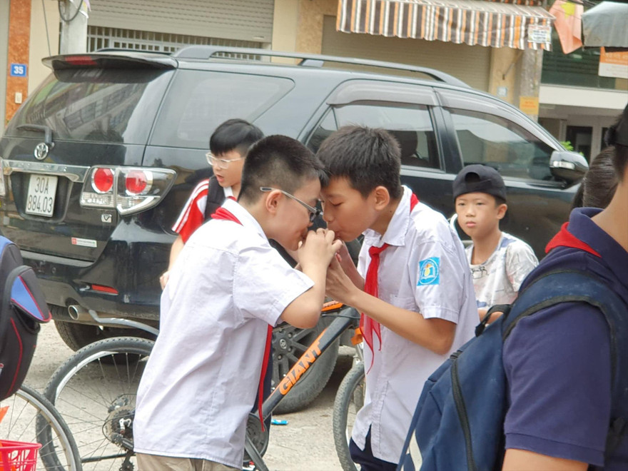Hai học sinh tại cổng trường Mễ Trì (Hà Nội) vô tư uống chung một cốc nước ngọt