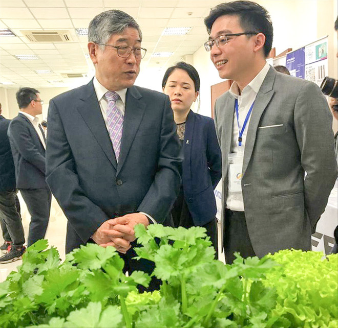 Anh Đặng Xuân Trường (ngoài cùng bên phải) giới thiệu về mô hình rau thủy canh ứng dụng công nghệ cao Ảnh: NVCC