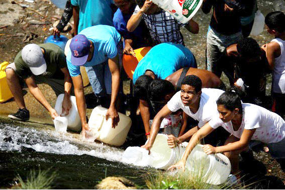 Người dân Venezuela đang hứng nước từ một miệng cống ảnh: Carlos Rawlins