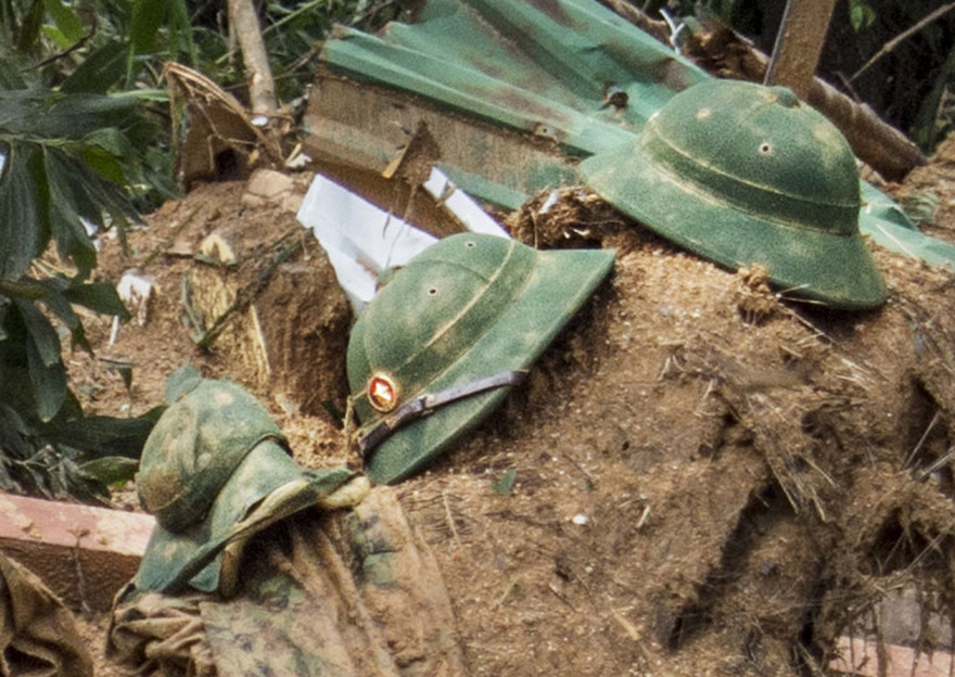 Ba chiếc mũ cối úp trên đống bùn đất gần mép vực Ảnh: VĂN CHƯƠNG