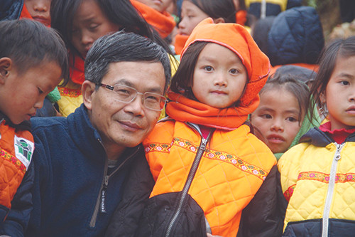 Nhà báo Trần Đăng Tuấn với trẻ em vùng cao mà ông và cộng sự mang cho cái ăn, cái mặc Ảnh: Phạm Ngọc Tiến