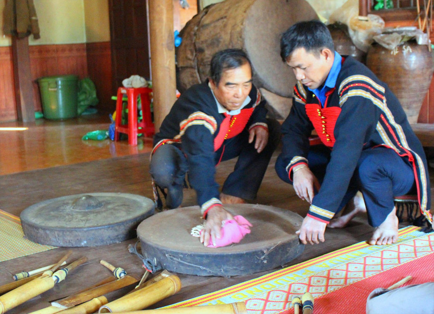 Ông Y Môi (bìa trái) bên chiếc chiêng cái của gia đình 