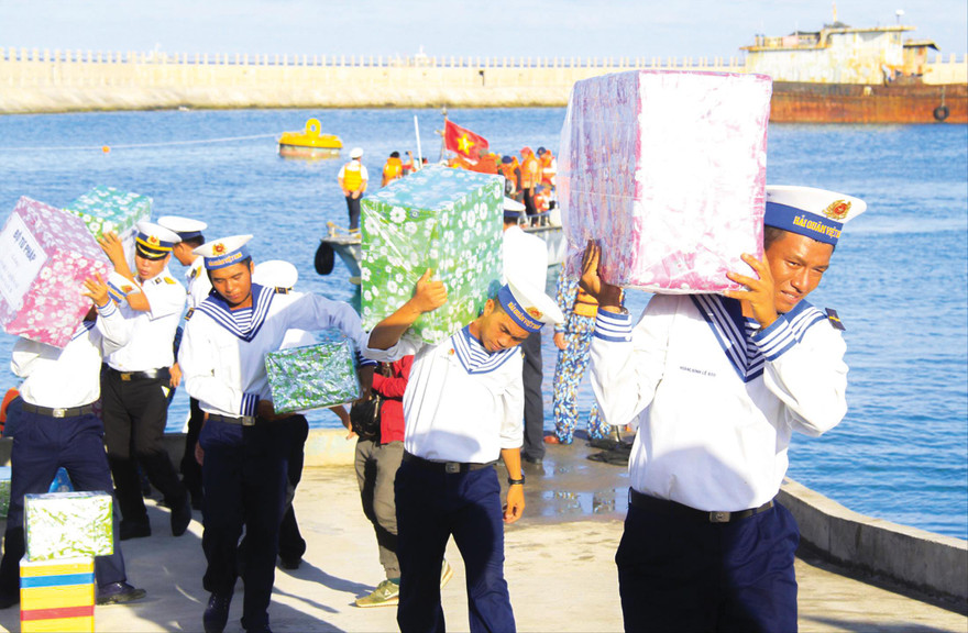 Các chiến sĩ vận chuyển quà tặng của đoàn công tác đến với Trường Sa. Ảnh: Trường Phong