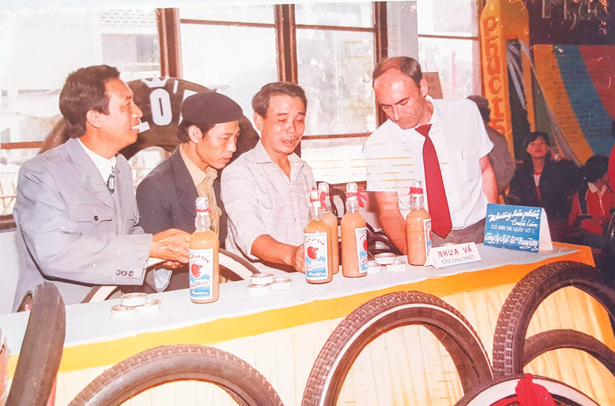Ông Nguyễn Văn Chẩn (thứ 2 từ trái sang) giới thiệu mặt hàng lốp và nhựa vá săm Quyết Thắng tại Hội chợ Triển lãm Giảng Võ. ẢNH: GIA ĐÌNH CUNG CẤP 