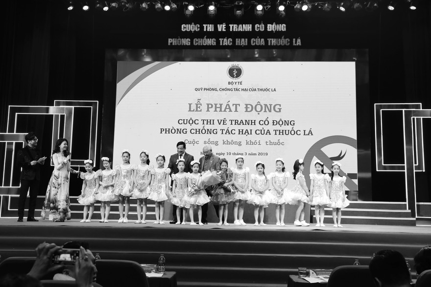 PGS. TS. Lương Ngọc Khuê, Cục trưởng Cục Quản lý Khám - chữa bệnh (Bộ Y tế), Giám đốc Quỹ Phòng, chống tác hại của thuốc lá và họa sỹ Trần Khánh Chương, Chủ tịch Hội Mỹ thuật Việt Nam tặng hoa cho các em thiếu nhi