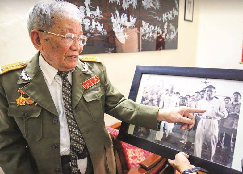 Đại tá Đoàn Sự bên tấm hình của mình phiên dịch cho Bác Hồ ở Bắc Kinh, Trung Quốc. Ảnh: Như Ý 