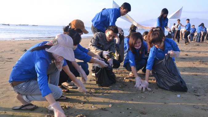 Thanh niên tình nguyện làm vệ sinh môi trường bờ biển trong hoạt động "Vì biển đảo quê hương". Ảnh: Hồng Vĩnh.