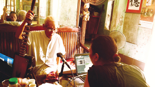 Nhà nghiên cứu Bùi Trọng Hiền bên cạnh cụ Nguyễn Phú Đẹ - nghệ nhân đàn đáy nhà nghề duy nhất còn sống. Ảnh: Nhân vật cung cấp.