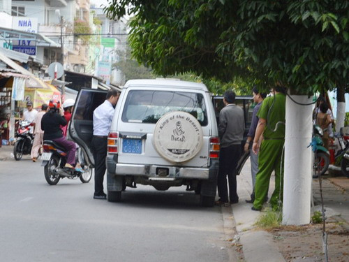 Ông Thống (người thứ 3 từ phải qua) bị công an áp giải lên xe - Ảnh: Châu Khánh 