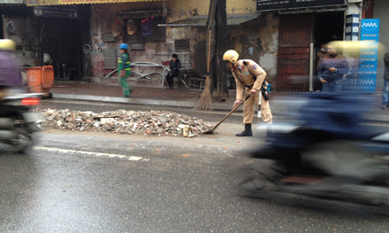 Ba cảnh sát giao thông đội mưa dọn phế thải