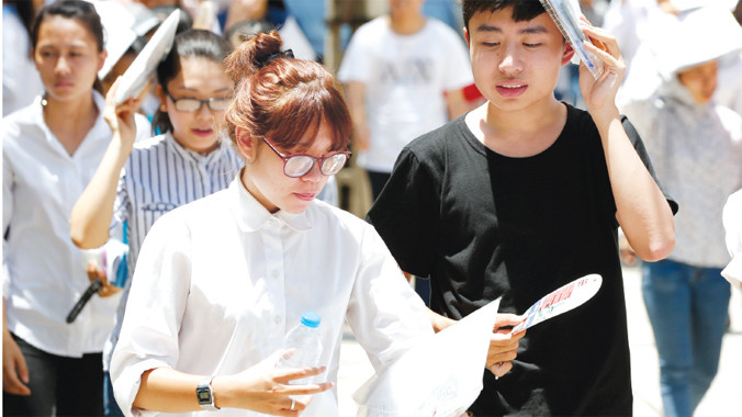 Thí sinh soi lại với đáp án sau giờ thi môn Vật lý tại Đại học Bách khoa Hà Nội. Ảnh: Hồng Vĩnh.