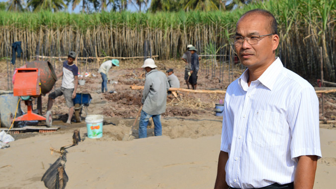 Hiệu trưởng Nhỏ với khu đất hiến đang xây trường. Ảnh: Xuân Lương.