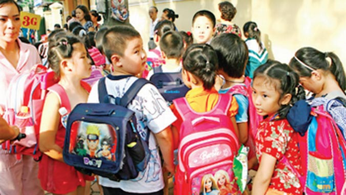 Thu phí BHYT chọn gói 15 tháng với mức tăng lên 4,5% làm nặng thêm vai các em học sinh. Ảnh: Hồng Vĩnh.