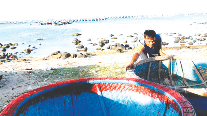 Ngư phủ Nguyễn Văn Hùng (làng chài Ghành Hang) sắp xếp những thuyền thúng chuẩn bị cho chuyến ra khơi tiếp theo. Ảnh: Đại Dương.