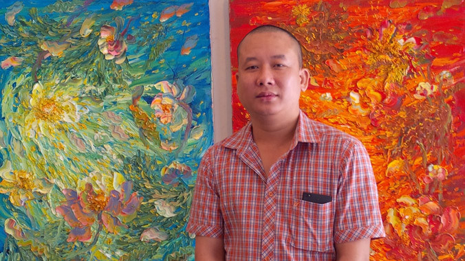 Họa sĩ Vũ Tuyên bên các bức tranh sen. Ảnh: Trung Dũng.