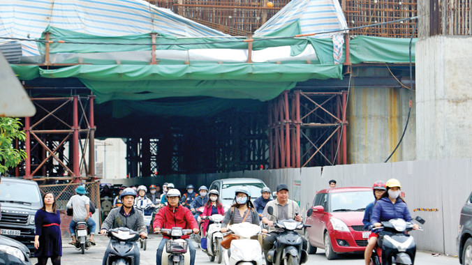 Vào giờ cao điểm lưu lượng xe đi qua công trường ga La Thành thường ùn tắc với giàn giáo chỉ là những ống thép liên kết khiến nhiều người dân lo lắng khi đi qua đây. Ảnh: Như Ý. 