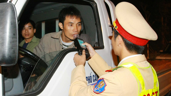 Cảnh sát giao thông đang kiểm tra nồng độ cồn của người tham gia giao thông. Ảnh: Hồng Vĩnh. 
