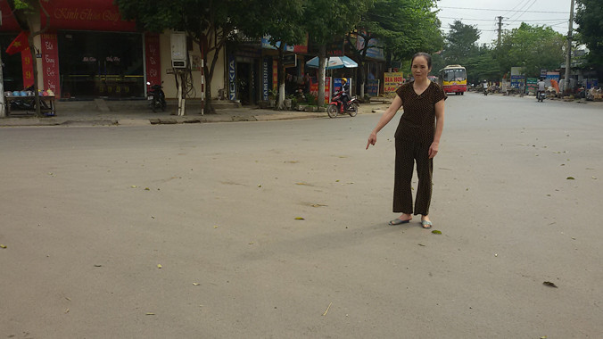 Bà Gang chỉ đoạn đường bà bị bắt quỳ lạy.