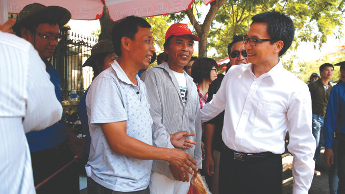 Phó Thủ tướng Vũ Đức Đam trò chuyện với người nhà thí sinh tại cụm thi ở Hà Nội. Ảnh: Hồng Vĩnh.