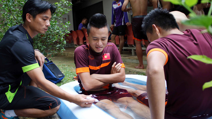 Bác sĩ kiểm tra độ lạnh khi cho các cầu thủ Việt Nam ngâm nước đá sau buổi tập nhằm giúp cầu thủ nhanh chóng phục hồi thể lực. Ảnh: VSI.