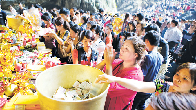 Ban quản lý Chùa Hương cho đặt bát đồng lớn để người dân đặt tiền giọt dầu tránh tình trạng đặt vương vãi hay giắt vào tượng Phật. Ảnh: Như Ý.
