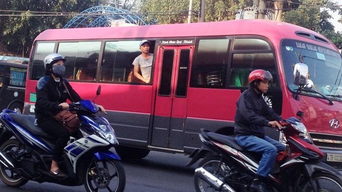 Một phụ xe nhô đầu ra cửa sổ để chèo kéo, “bắt” khách trên Quốc lộ 13.