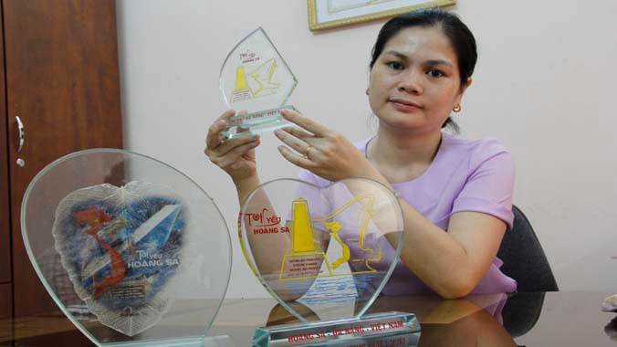 Chị Lê Thị Mỹ Hạnh và vật lưu niệm Hoàng Sa do chị thiết kế. Ảnh: Thanh Trần.