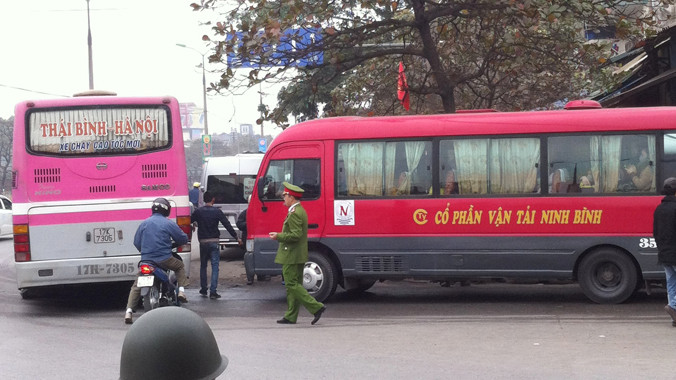 Xe khách dàn hàng ngang, đứng bắt khách trước cổng bến Giáp Bát sáng 13/2 nhưng cảnh sát chỉ đứng nhìn. Ảnh: Anh Trọng.
