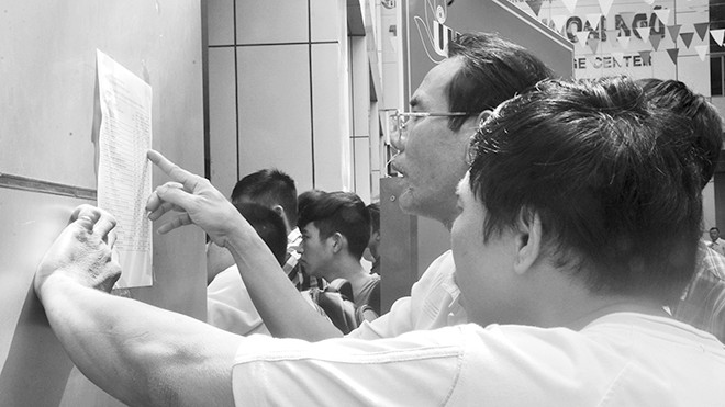 Phụ huynh và thí sinh xem xét điểm số tại ĐH Công nghiệp TPHCM. Ảnh: Nguyễn Dũng.