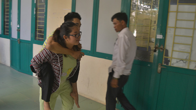 Nội được hai người chị cõng đến trường. Ảnh: Phạm Nhài.