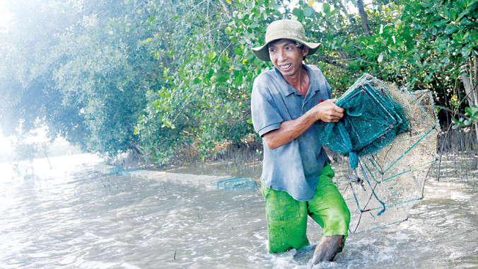 Ông Lệnh đi săn bạch buộc trong rừng ngập mặn Cần Giờ. Ảnh: Ngô Bình.