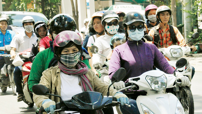 Nóng chảy mỡ nhưng người đi đường vẫn phải áo đơn áo kép tránh nắng gay gắt. Ảnh: Văn Minh.