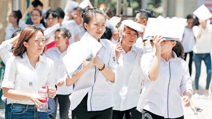 Thí sinh đội nắng ra về sau khi làm bài thi quốc gia năm 2015 tại điểm thi Bách Khoa, Hà Nội. Ảnh: Hồng Vĩnh.