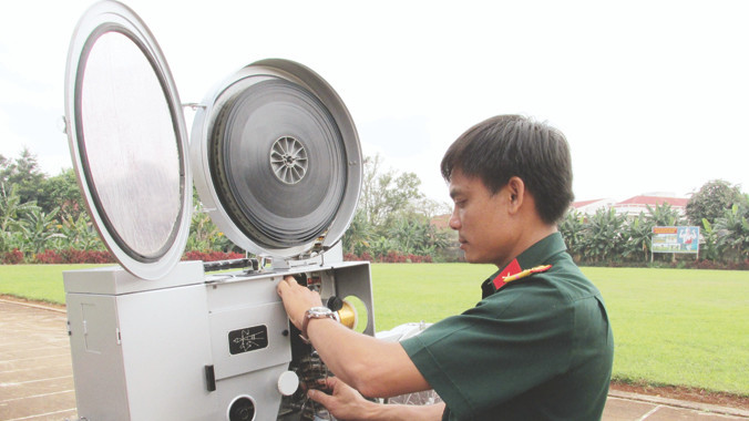 Anh Trương Huy Thái ráp phim vào máy, chuẩn bị trước cho buổi chiếu phim.