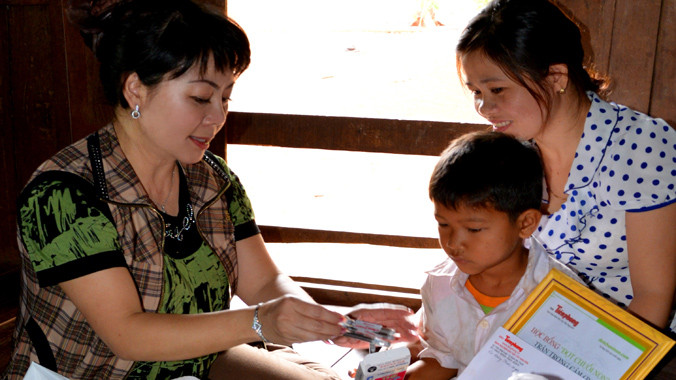 Tác giả trao quà và học bổng cho một học trò mồ côi mắc bệnh hiểm nghèo.