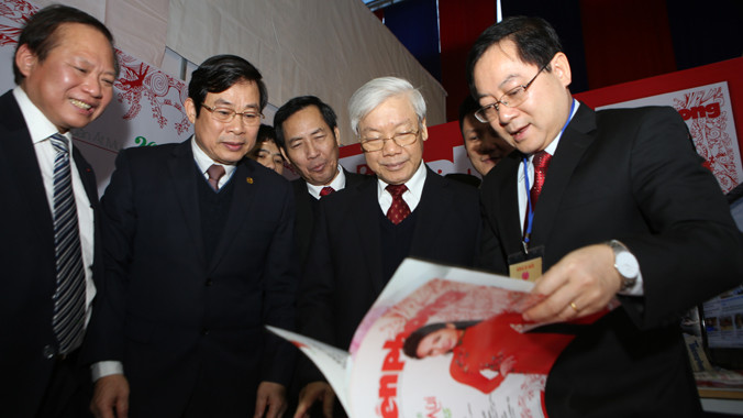 Tổng Bí thư Nguyễn Phú Trọng đến thăm gian trưng bày của báo Tiền Phong tại Hội Báo Xuân 2015. Trong ảnh: Tổng Biên tập báo Tiền Phong, ông Lê Xuân Sơn giới thiệu với Tổng Bí thư về các ấn phẩm Xuân của báo Tiền Phong.