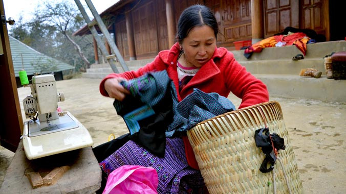 Mục tiêu Bộ LĐ, TB&XH xác định cho năm 2015 là tiếp tục đẩy mạnh các chính sách, dự án giảm nghèo. Trong ảnh: Người dân may áo mới cho con tại bản Pà Cò thuộc huyện Mai Châu, tỉnh Hòa Bình. Ảnh: Anh Tuấn.