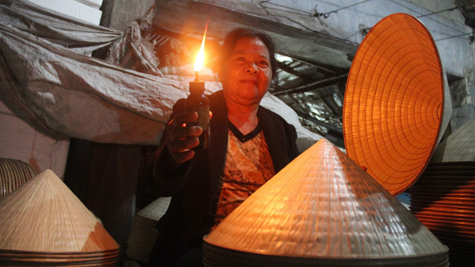 Chợ đêm nón lá Cát Tân họp dưới ánh sáng của những ngọn đèn dầu.