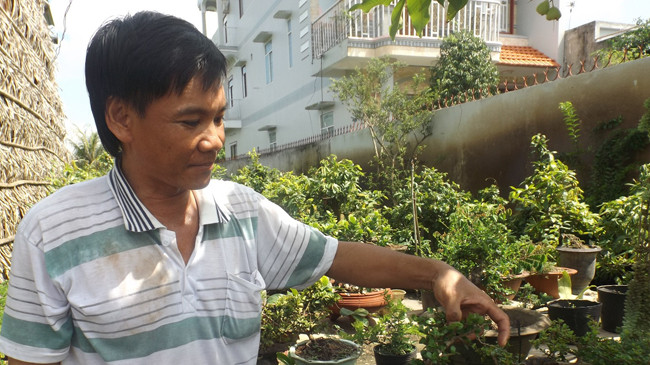 Anh Hồ Hoàng Tâm bên vườn cây cảnh của mình. Ảnh: Hòa Hội.