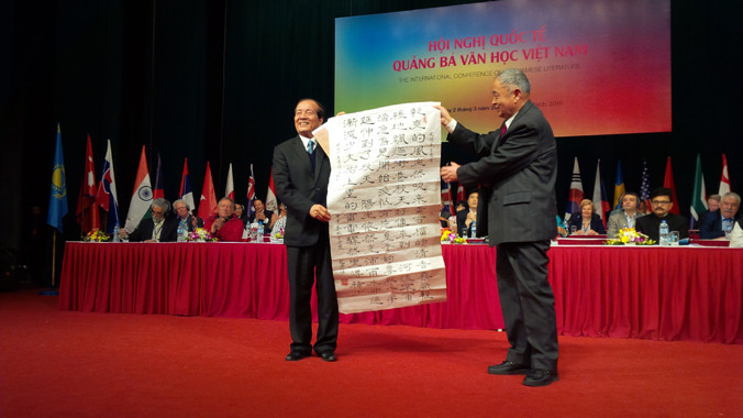 Học giả Chúc Ngưỡng Tu tặng bức thư pháp bài “Sang thu” của Hữu Thỉnh cho chính tác giả. Ảnh: Trung Dũng.