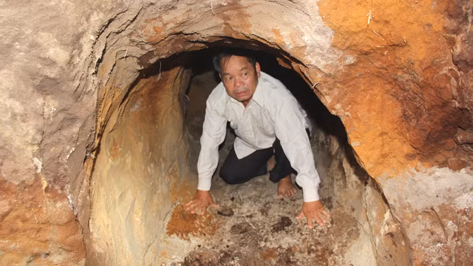 Ông Trương Hoài Lâm bên trong địa đạo vừa được phát lộ, nơi chị gái mình hi sinh. Ảnh: Nguyễn Thành.