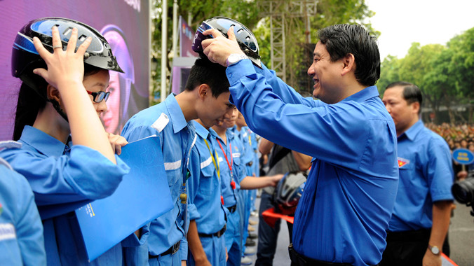 Bí thư Thứ nhất T.Ư Đoàn Nguyễn Đắc Vinh tặng mũ bảo hiểm đạt chuẩn cho tình nguyện viên đội phản ứng nhanh giao thông của Thành Đoàn Hà Nội. Ảnh: Xuân Tùng.