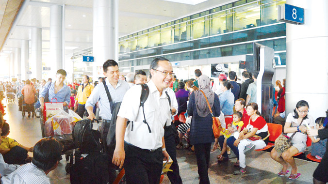 Bà con kiều bào về quê đón Tết Ất Mùi qua sân bay Tân Sơn Nhất. Ảnh: Ngô Bình.