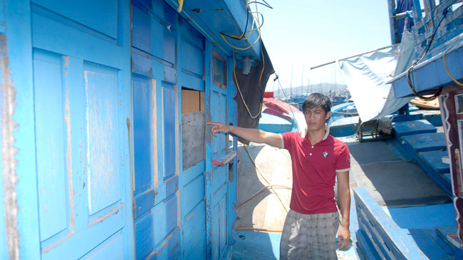 Con trai anh Quen chỉ vào cửa sổ bị vòi rồng hất băng mới được sửa chữa lại.